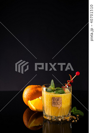 Fresh cocktail with orange, mint and ice on black glass backgorund, copy space 40701510