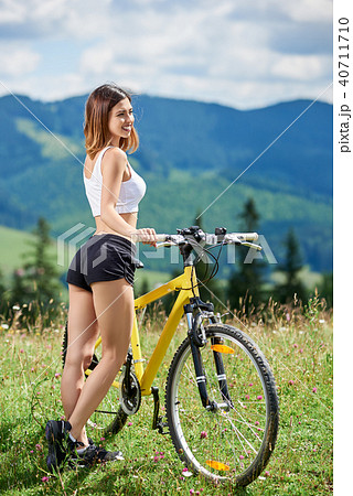 Young happy woman cycling on mountain bike at summer day Young happy woman cycling on mountain bike at summer day 40711710