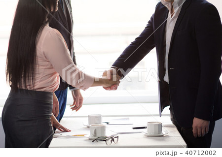 Three business people sign agreement at restaurant Three business people sign agreement at restaurant 40712002