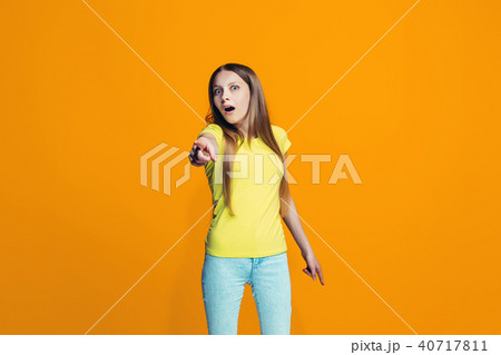 Beautiful teen girl looking suprised isolated on orange Beautiful teen girl looking suprised isolated on orange 40717811
