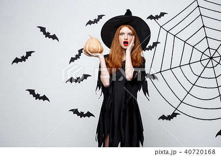Portrait of beautiful caucasian witch holding pumpkin for celebrating Halloween. Portrait of beautiful caucasian witch holding pumpkin for celebrating Halloween. 40720168