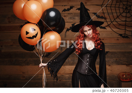 Halloween Witch Concept - Beautiful caucasian woman in witch costumes celebrating Halloween posing 40720305