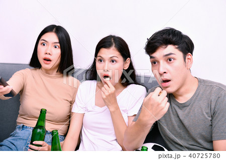 Concept of cheering. Asian teenagers watching football on televi 40725780