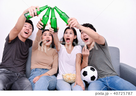 Concept of cheering. Asian teenagers watching football on televi 40725787