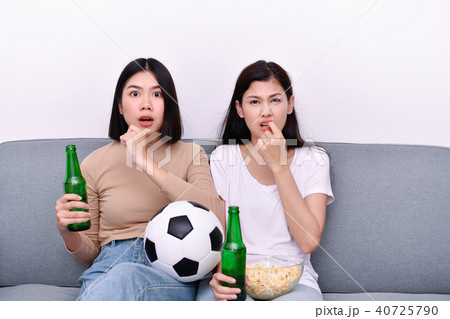 Concept of cheering. Asian teenagers watching football on televi 40725790