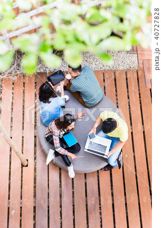 Young employees using modern wireless technology while working outdoors Young employees using modern wireless technology while working outdoors 40727828