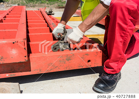 Worker installing metallic framing while working 40727888