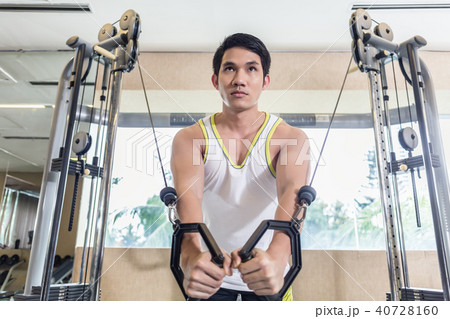 Asian handsome man exercising cable crossover for chest muscles Asian handsome man exercising cable crossover for chest muscles 40728160