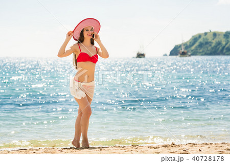 Fashionable fit young woman talking on mobile phone on the beach Fashionable fit young woman talking on mobile phone on the beach 40728178