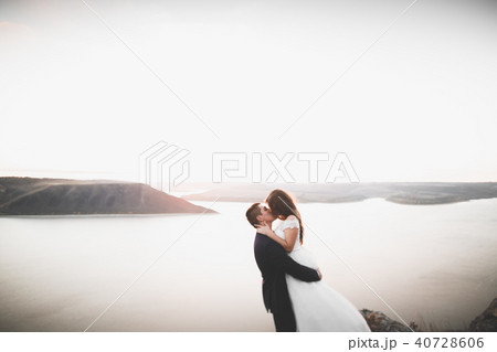 Happy and romantic scene of just married young wedding couple posing on beautiful beach Happy and romantic scene of just married young wedding couple posing on beautiful beach 40728606