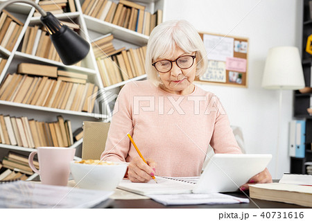 Earnest senior woman taking notes 40731616