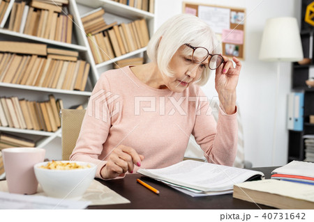 Focused senior woman reading task Focused senior woman reading task 40731642