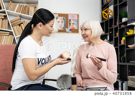 Glad female volunteer using face powder 40731958