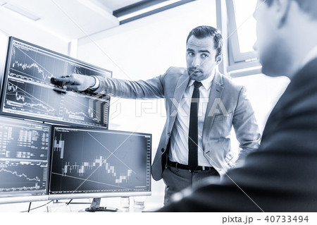 Stock brokers trading online in corporate office. Stock brokers trading online in corporate office. 40733494