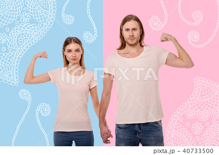 Nice couple holding hands and showing their strong muscles Nice couple holding hands and showing their strong muscles 40733500