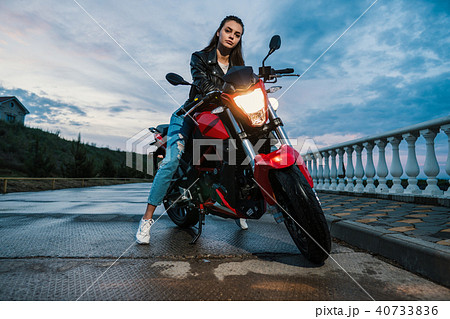 Biker girl in a leather jacket on a black and red color motorcycle Biker girl in a leather jacket on a black and red color motorcycle 40733836