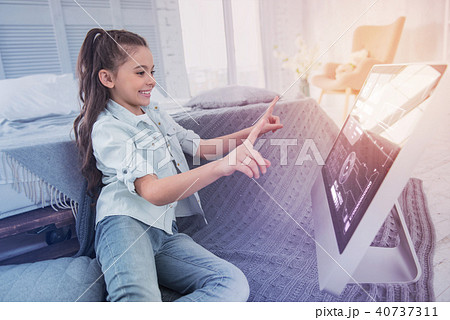 Smiling girl looking happy while sitting in front of computer 40737311