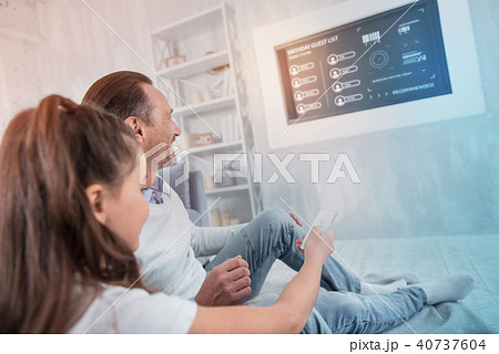 Young father smiling while his daughter holding a remote control 40737604