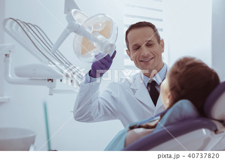 Joyful male dentist verifying oral clean 40737820