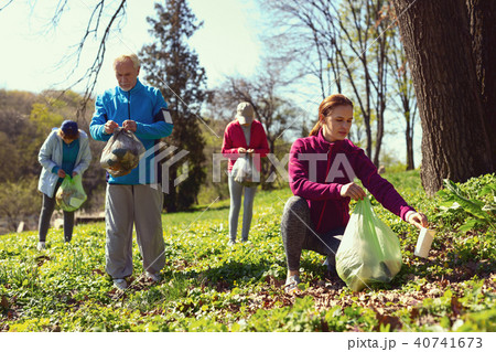 Inspired team gathering litter in the forest 40741673