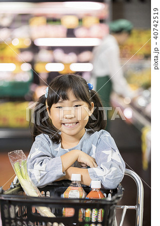 スーパーで買い物をする小学生の写真素材