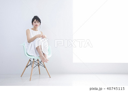 椅子に座る若い女性の写真素材