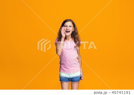 Isolated on yellow young casual teen girl shouting at studio 40745191