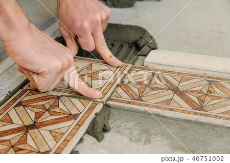 Worker putting tiles on the floor. Worker putting tiles on the floor. 40751002