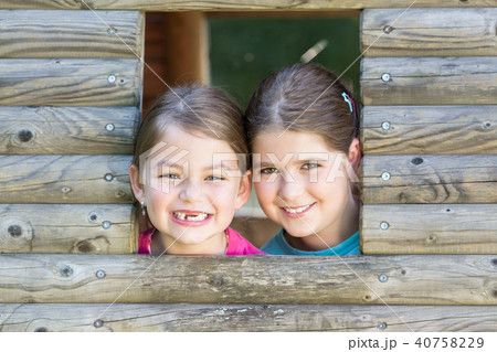 Two sisters playing in tree house Two sisters playing in tree house 40758229