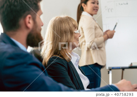 Middle-aged business woman presenting her opinion during a meeting Middle-aged business woman presenting her opinion during a meeting 40758293