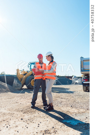 Worker and engineer on earthworks construction site planning Worker and engineer on earthworks construction site planning 40758332