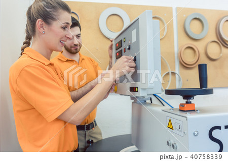 Team of carpenters programming CNC machine in their workshop Team of carpenters programming CNC machine in their workshop 40758339