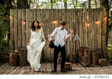 Merry happy young couple have fun near a wooden installation. Merry happy young couple have fun near a wooden installation. 40760722