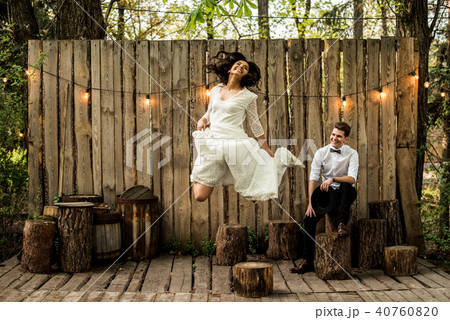Merry happy young couple have fun near a wooden installation. Merry happy young couple have fun near a wooden installation. 40760820