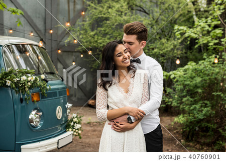 Merry happy young couple hugging near a retro bus 40760901