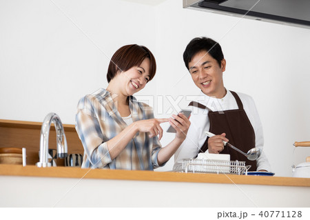 レシピ動画を見ながら料理をする夫 40771128