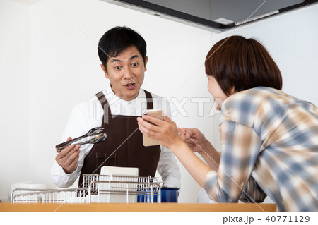 レシピ動画を見ながら料理をする夫 40771129