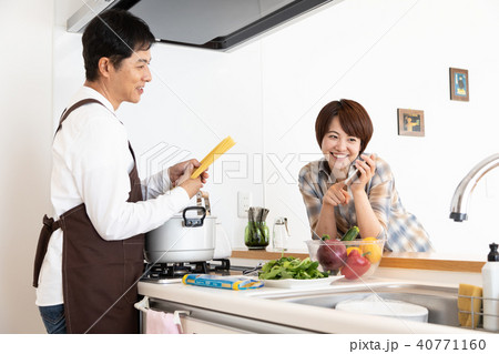 レシピ動画を見ながら料理をする夫 40771160