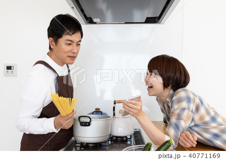 レシピ動画を見ながら料理をする夫 40771169