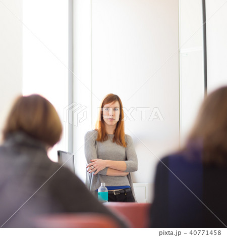 Woman giving presentation in lecture hall at university. Woman giving presentation in lecture hall at university. 40771458