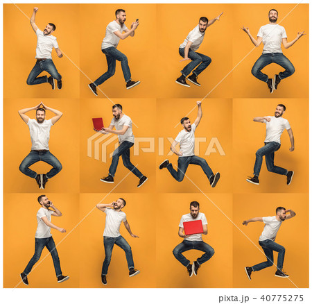 Image of young man over orange background using laptop computer while jumping. 40775275