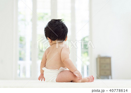 座った赤ちゃんの後ろ姿の写真素材