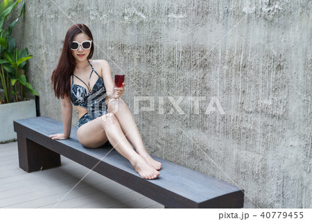 wwoman on deckchair and holding a glass in pool 40779455
