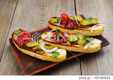Pickled gherkin and salmon bruschettas on table Pickled gherkin and salmon bruschettas on table 40780683