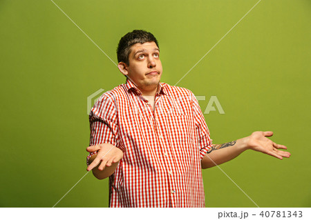 Beautiful man looking suprised and bewildered isolated on green Beautiful man looking suprised and bewildered isolated on green 40781343