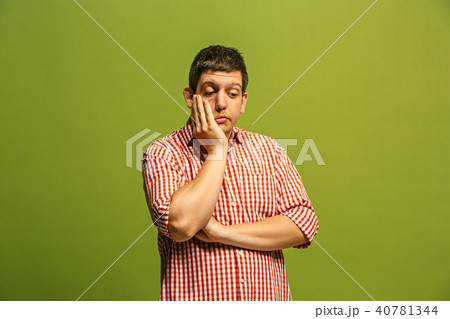 Let me think. Doubtful pensive man with thoughtful expression making choice against green background 40781344