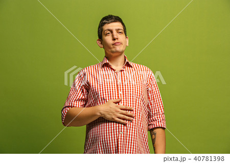 The happy businessman standing and smiling against green background. The happy businessman standing and smiling against green background. 40781398