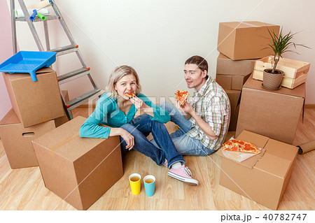 Photos of women and men eating pizza among cardboard boxes 40782747