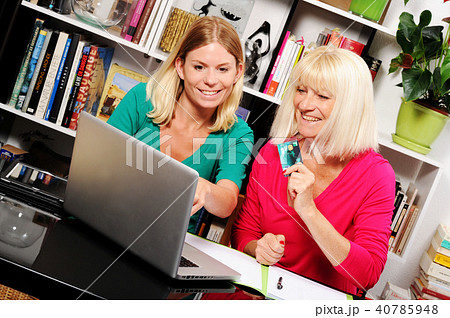 Senior woman and caregiver with laptop and credit card Senior woman and caregiver with laptop and credit card 40785948