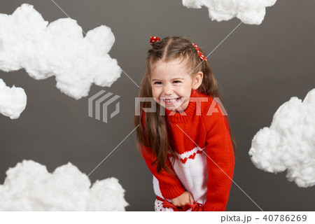 girl playing with clouds, dressed in red sweater girl playing with clouds, dressed in red sweater 40786269